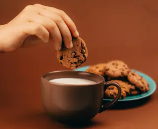 Çikolata parçacıklı kurabiyeler ve bir fincan süt
