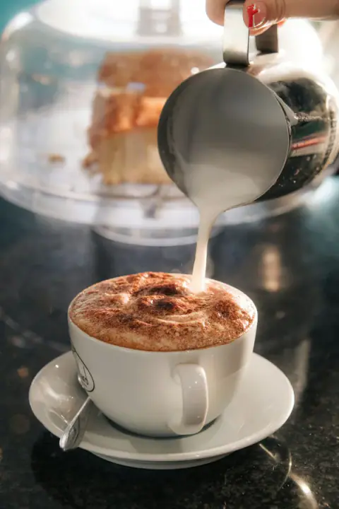 Fincana süt dökülen köpüklü latte