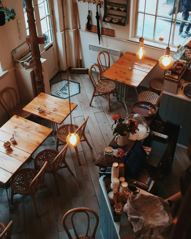 Ahşap masalı, sarı ışıklı sıcak bir kafe salonu