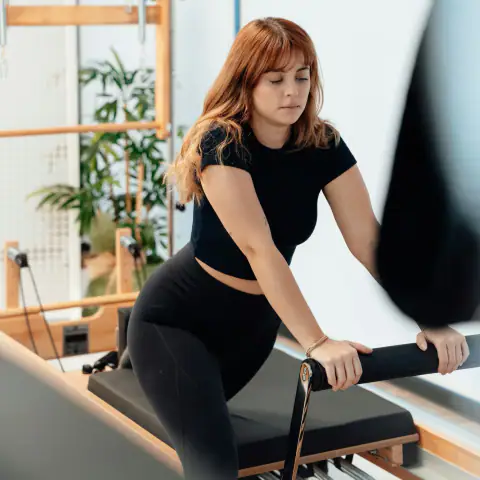 Reformer üzerinde egzersize hazırlanan kadın